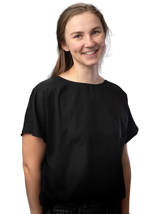 Mustapaitainen naishenkilö katsoo kohti.