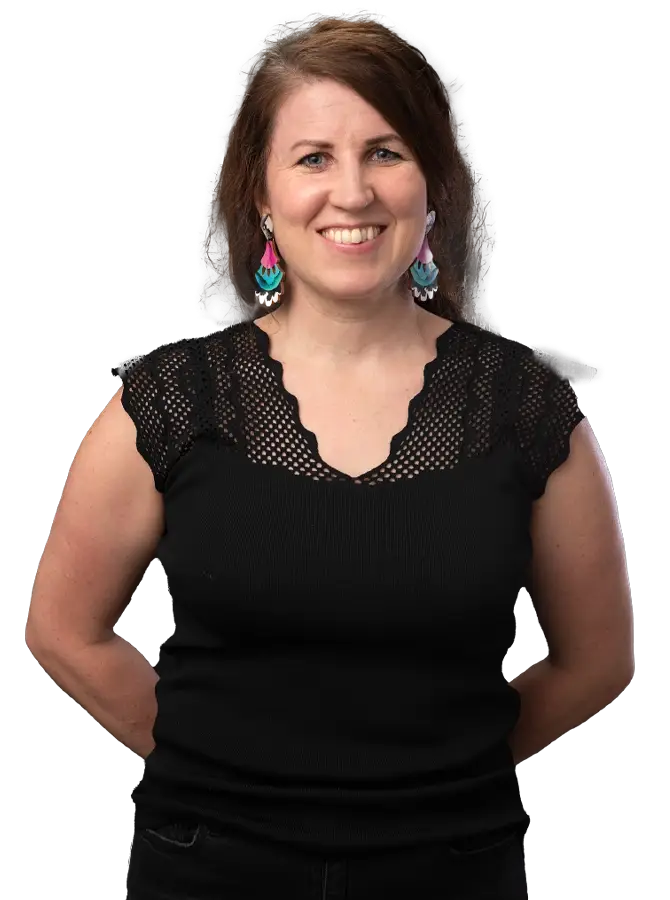 Mustapaitainen naishenkilö katsoo kohti. Kädet selän takana.